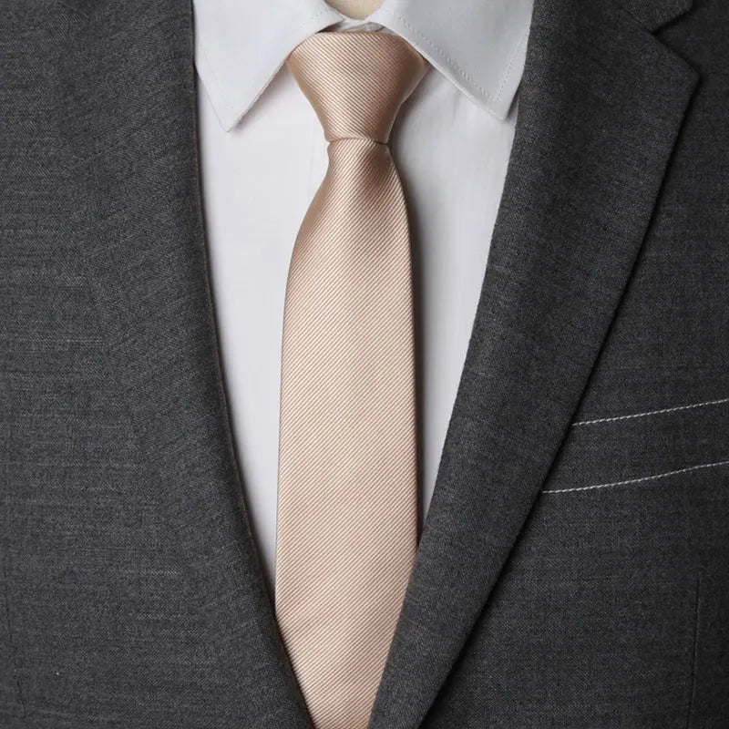 A close-up of a tan striped necktie worn with a gray suit jacket and white shirt.