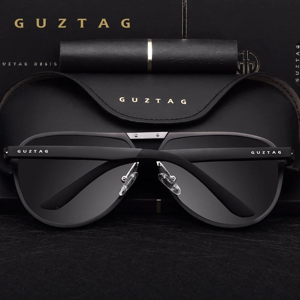 Ein Paar schwarze GUZTAG Sonnenbrille liegt auf einer dunklen Oberfläche.
