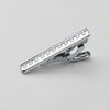 Primer plano de un clip de corbata de acero inoxidable para hombre con superficie texturizada.