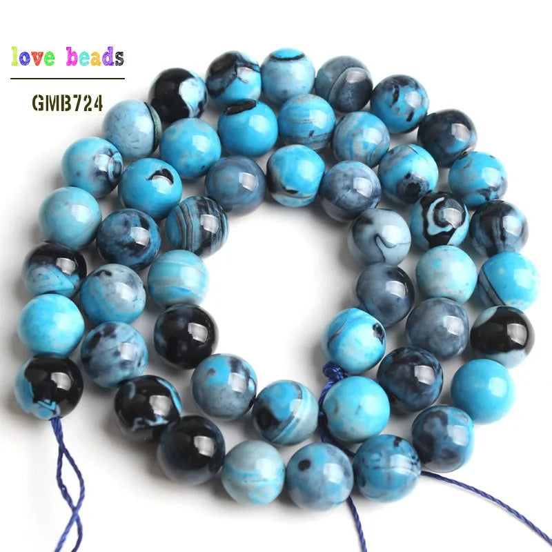 A strand of natural sky blue fire agate spacer beads for DIY jewelry, featuring various shades of blue and black.