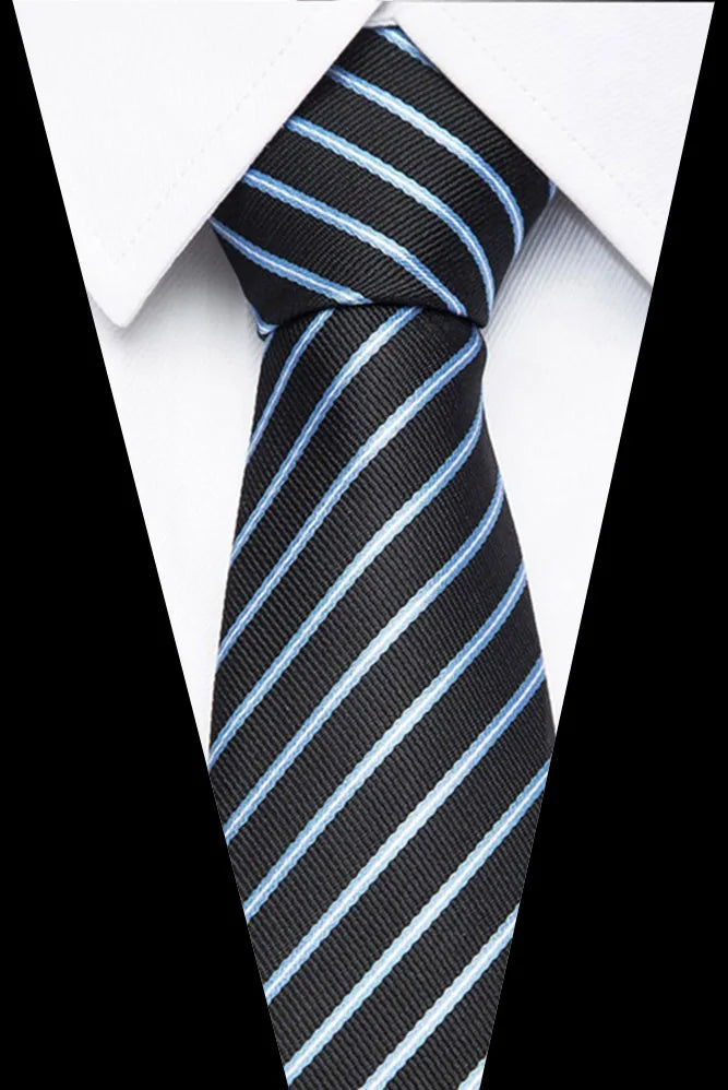 A close-up of a black and light blue striped silk jacquard tie worn with a white dress shirt.
