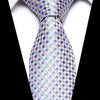A blue and gold patterned silk jacquard tie worn against a white shirt.