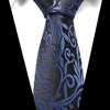 A close-up of a men's silk jacquard tie in black and blue paisley pattern worn against a white shirt.