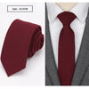 A deep burgundy slim fit wool neck tie worn under a gray suit jacket and white shirt.