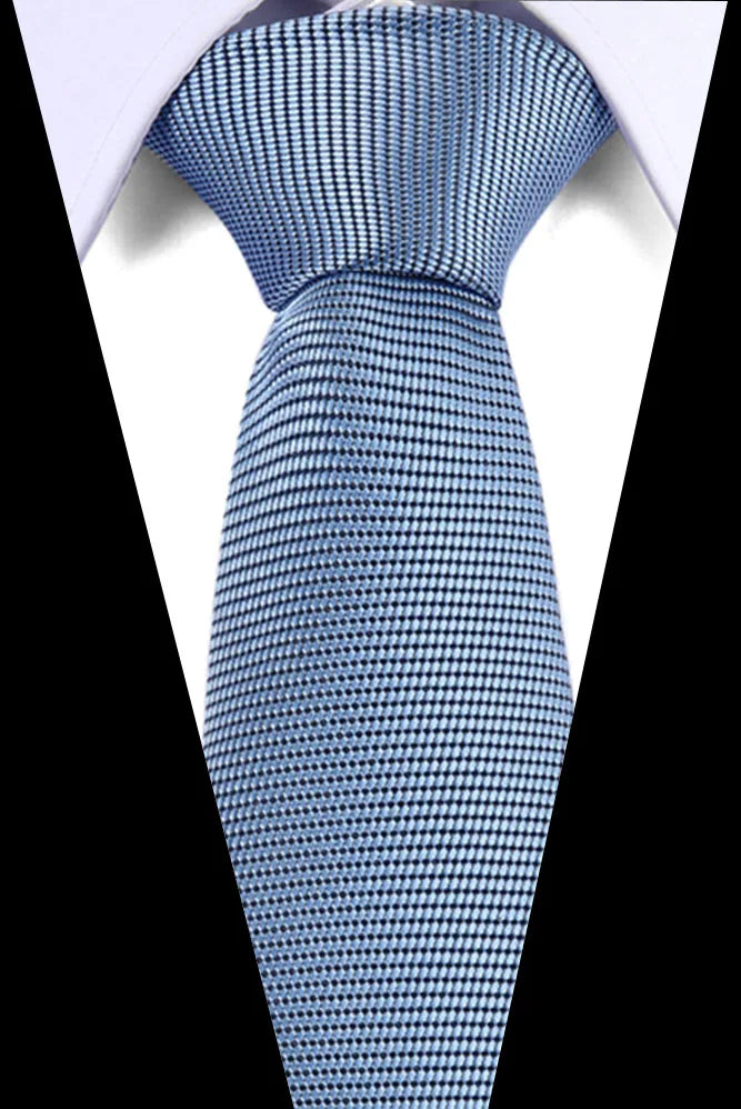 Close-up of a blue patterned silk tie tied in a knot against a white shirt background.