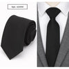 Black slim fit wool neck tie worn under a gray suit jacket and white shirt.