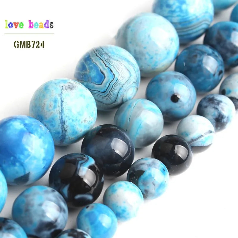 A collection of round, iridescent blue and teal agate spacer beads for DIY jewelry.