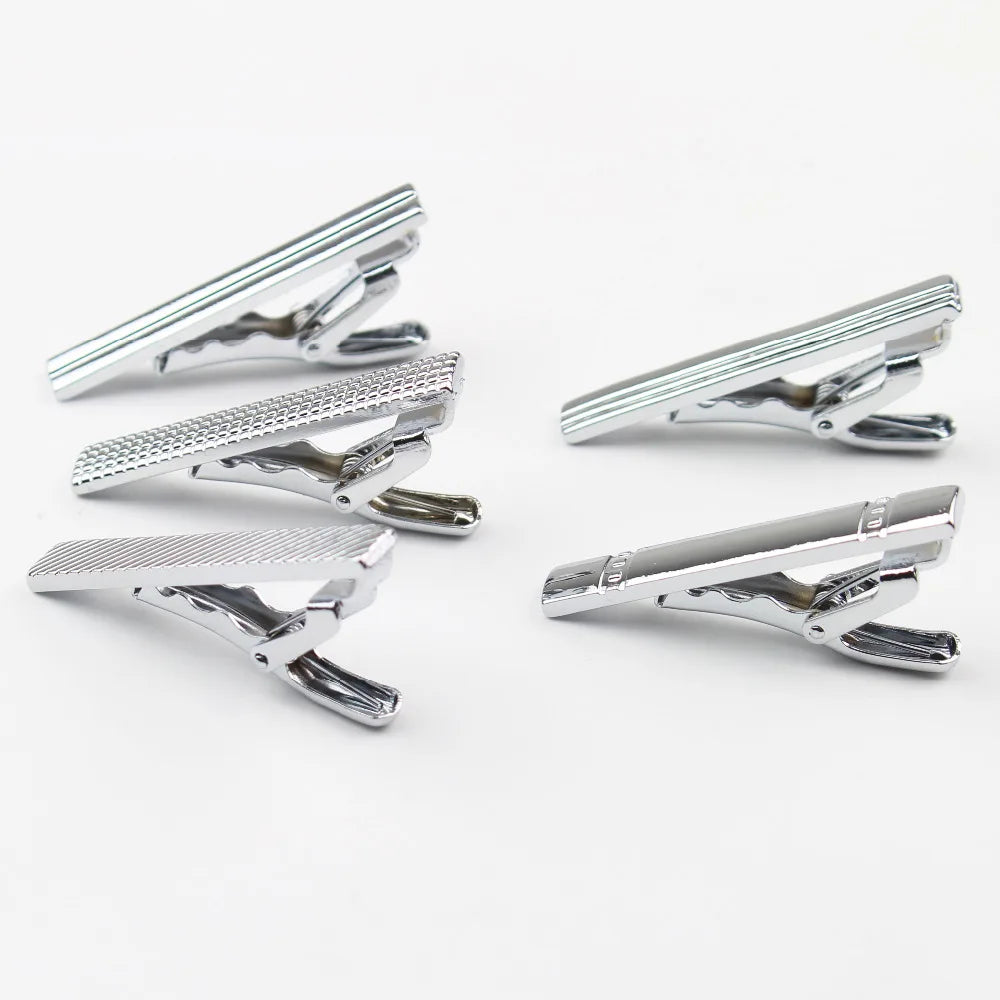 Colección de clips de corbata de acero inoxidable plateado mostrados desde varios ángulos.