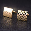 A pair of men's classic copper square cufflinks with a checkered pattern resting on a dark surface.
