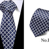 Navy blue silk jacquard tie folded and displayed against a white background.