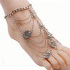 Silver fashion tassel anklet bracelet worn on a woman's foot.
