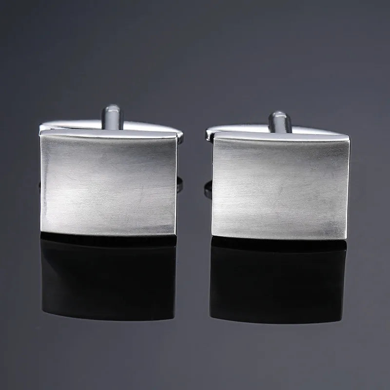 A pair of silver square cufflinks displayed against a dark gray background.