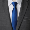A close-up of a navy blue striped tie worn with a white shirt under a gray suit jacket.