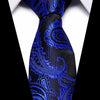 A close-up of a men's silk jacquard tie in royal blue and black paisley pattern worn against a white shirt.