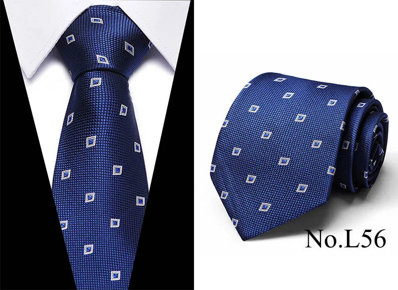 A dark blue silk jacquard tie shown folded and laid flat, featuring a repeating geometric pattern.