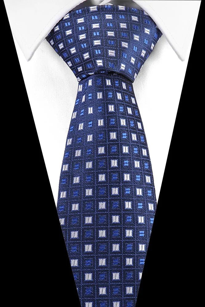 A dark blue silk jacquard tie with a repeating pattern of light blue diagonal stripes worn against a white shirt.