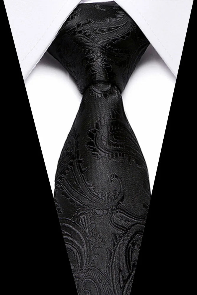 A close-up view of a black silk jacquard tie against a white shirt collar.