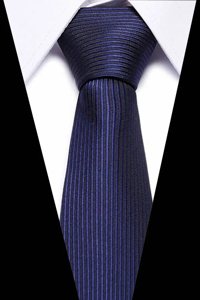 A close-up of a dark blue silk jacquard tie worn against a white shirt.