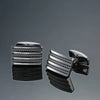 A set of men's classic copper square cufflinks displayed on a dark, reflective surface.