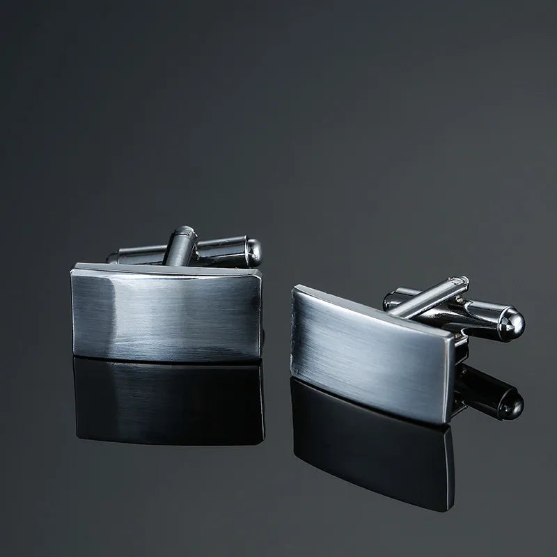 A pair of men's classic copper square cufflinks displayed against a dark gray background.