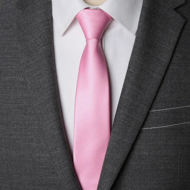 A pink striped tie worn under a gray suit jacket and white shirt.