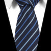 A dark blue striped silk jacquard tie worn with a white dress shirt.