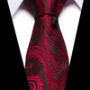 A close-up of a men's silk jacquard tie in deep red and black paisley pattern against a white shirt.