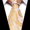 A close-up of a men's silk jacquard tie in pale pink and gold paisley pattern tied in a knot.