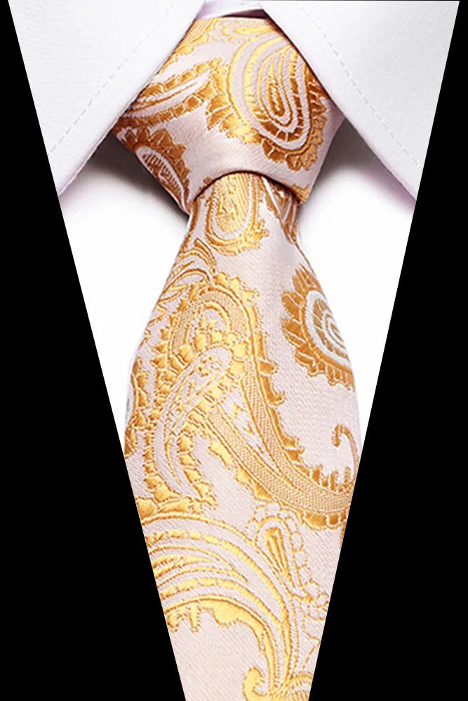 A close-up of a men's silk jacquard tie in pale pink and gold paisley pattern tied in a knot.