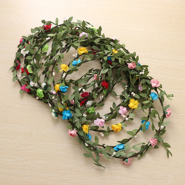 A green floral wreath or garland made of small, colorful fabric flowers used as a bohemian hair accessory.