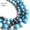 A close-up of natural sky blue fire agate spacer beads in various shades and sizes.
