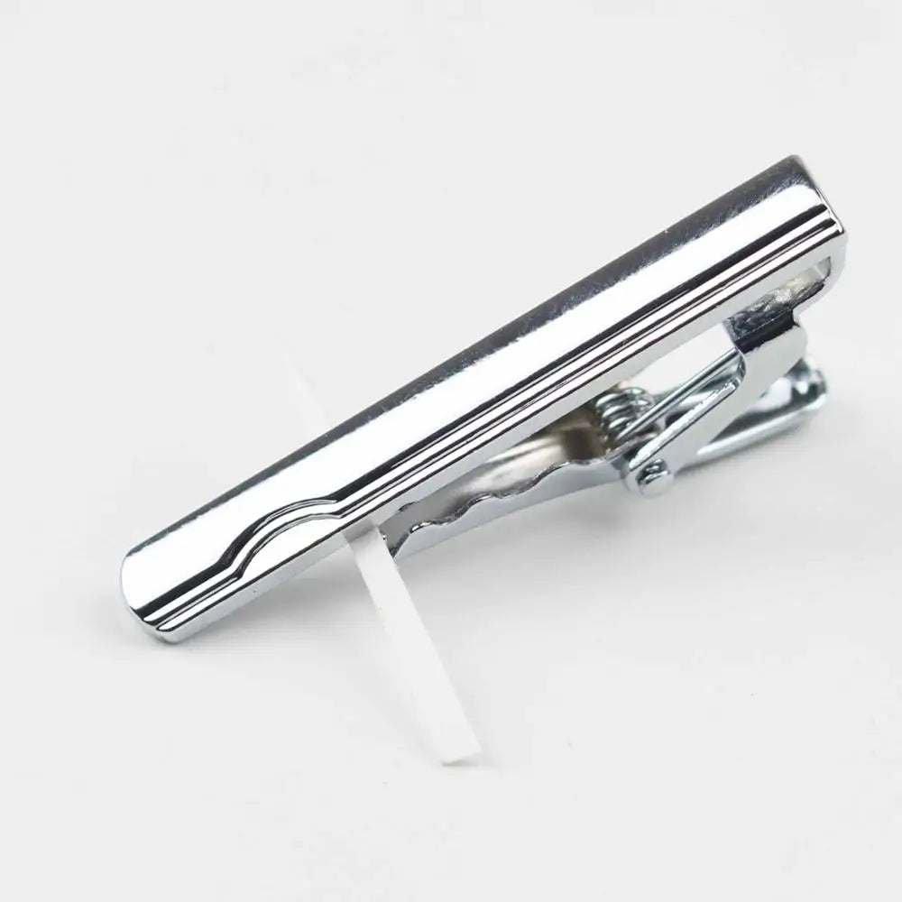 Vista cercana de un clip de prendedor de corbata de acero inoxidable plateado con un extensor de plástico blanco.