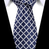 Navy blue silk jacquard tie with a white checkered pattern worn against a white shirt.