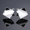 A pair of silver square cufflinks with black onyx accents displayed against a gray background.
