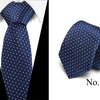Dark blue silk jacquard tie folded and displayed against a white background.