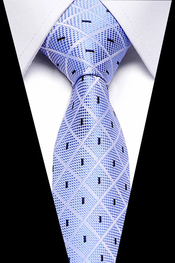 A close-up shot of a light blue silk jacquard tie worn against a white shirt.