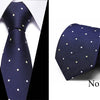 Navy blue silk jacquard tie with small gold dots shown against a white shirt.