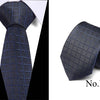 Dark blue silk jacquard tie folded and displayed against a white background.
