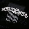 A silver rhinestone bridal hair comb tiara with delicate dangling strands shown against a black background.