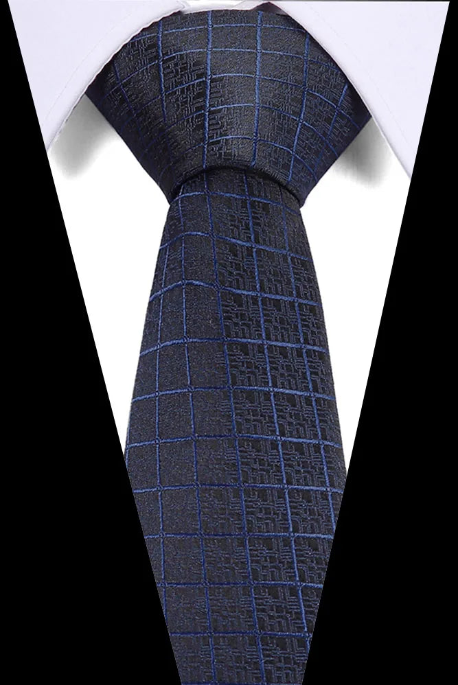 A dark blue silk jacquard tie is shown against a white shirt background.
