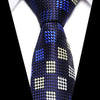 A dark blue silk jacquard tie with a repeating pattern of white and light blue squares.