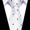 A white silk jacquard tie with black polka dots tied in a formal knot.