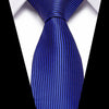 A close-up of a royal blue silk jacquard tie tied in a traditional knot against a white shirt.