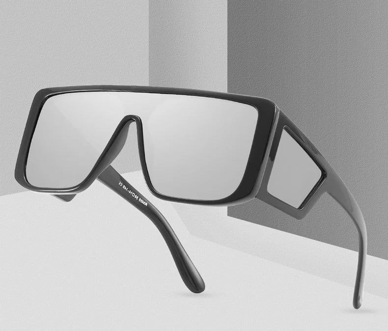 A pair of oversized gradient square sunglasses with black frames shown in a studio setting.