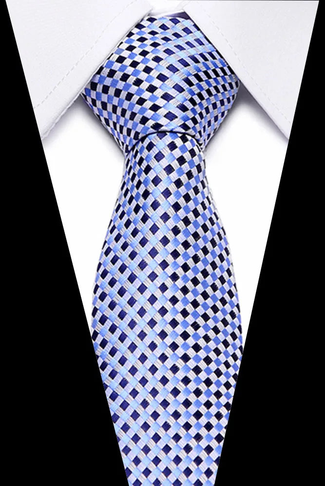 A close-up of a blue and white checkered silk jacquard tie worn under a white dress shirt.