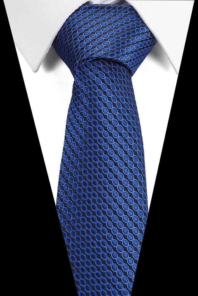 A close-up of a blue silk jacquard tie worn against a white shirt.