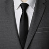 A close-up of a dark gray suit jacket with a white shirt and black tie.