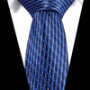 A close-up of a blue silk jacquard tie tied and displayed against a white shirt.