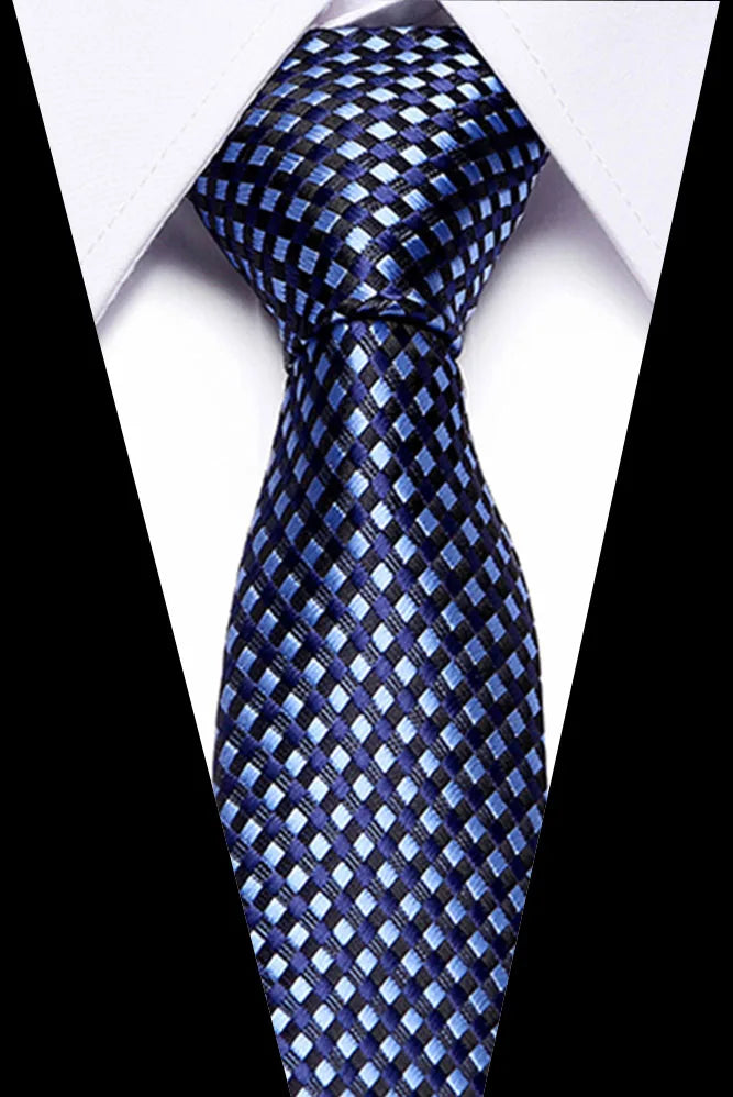 A dark blue silk jacquard tie with a checkered pattern displayed against a white shirt.