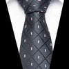 A black silk jacquard tie with a subtle pattern of pink accents.